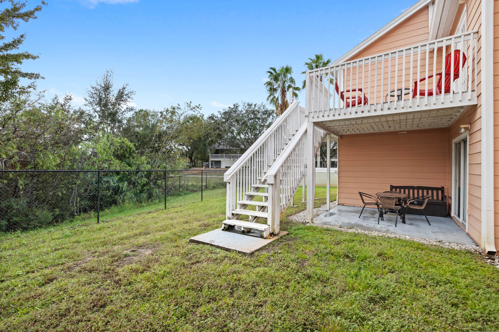 back patio with grass by a fence